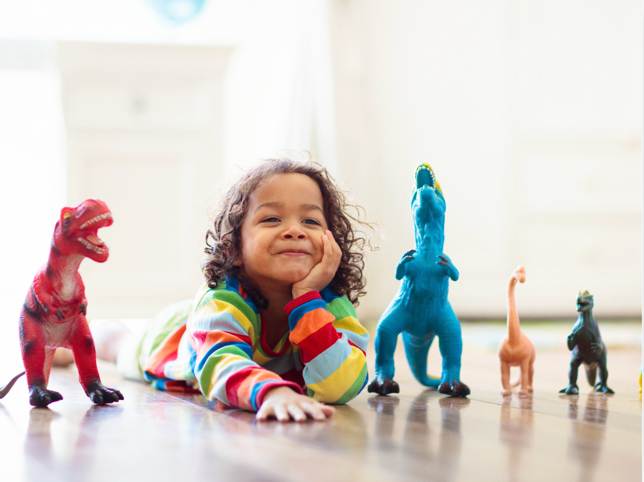 Child playing with dinosaur toys